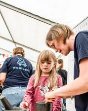 Erwachsene erklärt etwas einem kleinem Mädchen