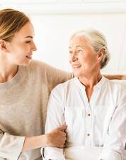 Junge Frau links wendet sich alter Frau rechts zu