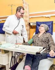 Arzt misst Blutdruck einer Patientin