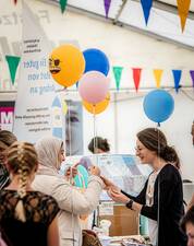 Zwei Frauen unterhalten sich, um sie herum hängen bunte Luftballos