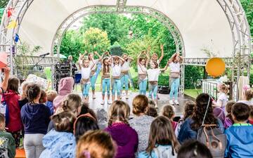 Kleine Bühne im Freien mit einer Kindertanzgruppe vor Publikum