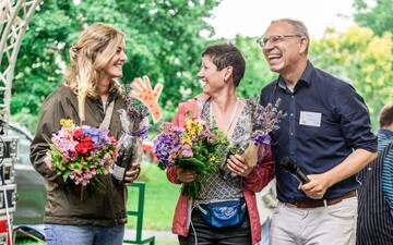 Kleine Bühne im Grünen mit zwei Frauen links und einem Mann rechts