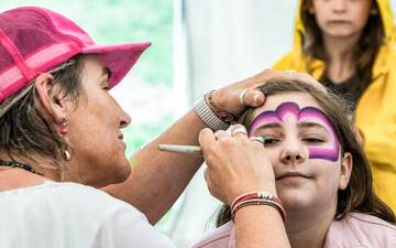 Eine Frau schminkt das Gesicht eines Mädchens